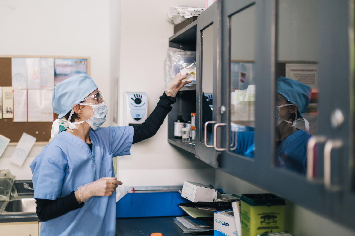 Australian nurse looking for medical PPE inside the cupboard in her office.